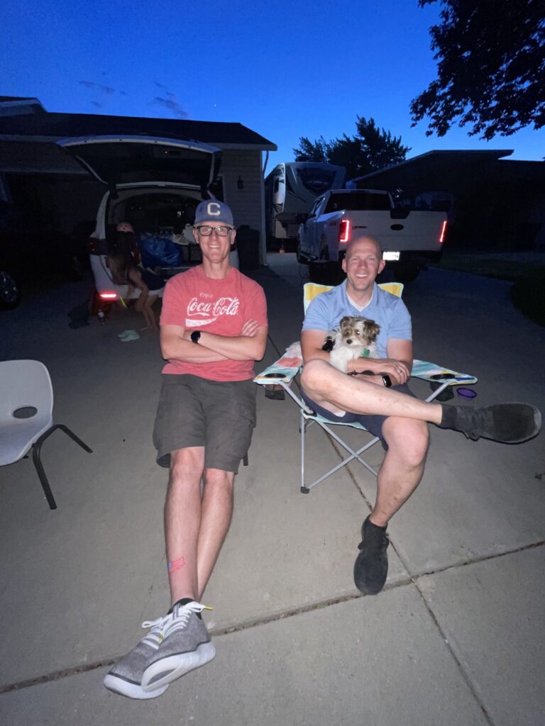 two husbands sitting together on driveway