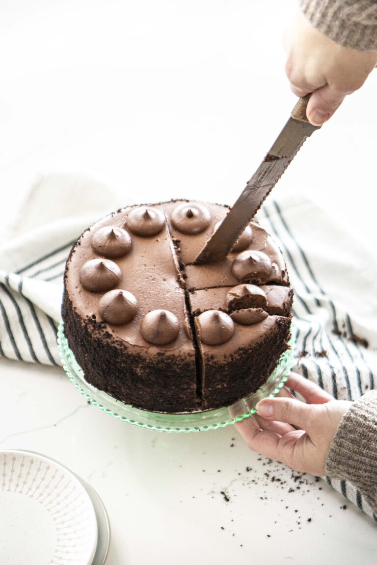 Slicing a round chocolate cake into pieces